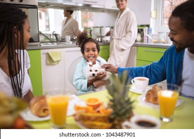 Family In Kitchen With Children And Cute Dog In The Morning Having Breakfast 