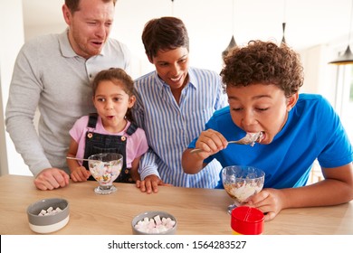 Family In Kitchen With Children Making And Eating Ice Cream Desserts