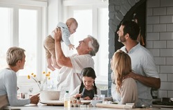 .Family, Kitchen And Grandpa Playing With Baby Having Fun, Bonding And Relax Together. Big Family, Support Or Care Of Grandfather Carrying Newborn With Mother, Father And Girl Child Cooking In House.