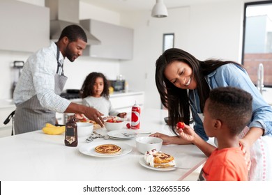 Family In Kitchen At Home Making Pancakes Together - Powered by Shutterstock