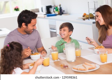 Family Laughing Around Breakfast In Kitchen