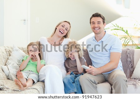 Family laughing on the sofa together