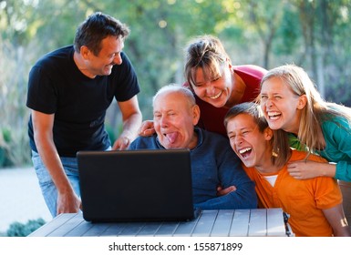 Family Laughing Together At The Funny Grandfather.