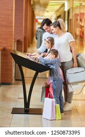 Family Learns About The Mall On The Touchscreen Information Kiosk