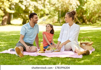 family, leisure and people concept - happy mother, father and daughter having picnic at summer park - Powered by Shutterstock