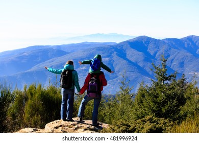 Family With Little Child Hiking In Mountains