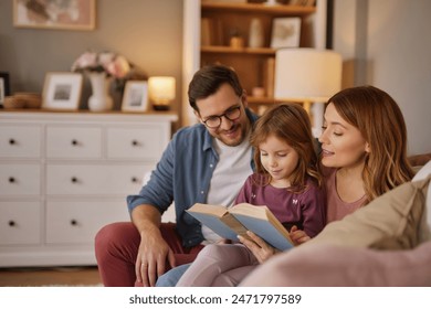 Family with little daughter reading book on sofa in living room - Powered by Shutterstock