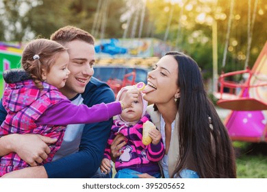 Family With Little Girls Enjoying Time At Fun Fair