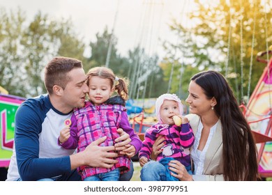 Family With Little Girls Enjoying Time At Fun Fair