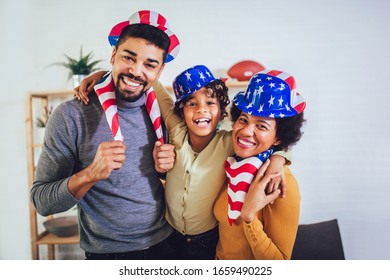 Family in living room on fourth of July with flags smiling