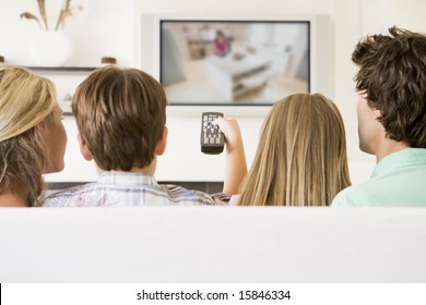 Family In Living Room With Remote Control And Flat Screen Television