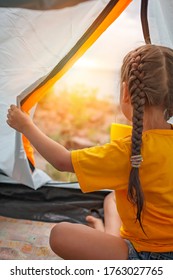 Family Local Getaway. Kid Sitting In The Camping Tent At Campsite And Looking At Sunset, Healthy Active Lifestyle, Safe Summer Staycation After Lockdown