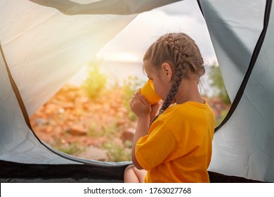 Family Local Getaway. Kid Sitting In The Camping Tent At Campsite And Looking At Sunset, Healthy Active Lifestyle, Safe Summer Staycation After Lockdown