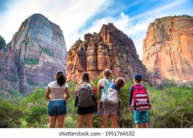 Family Looking Up At The Amazing Rock Formations At Zion National Park In Utah. A Diverse Group Of Children And Adults Enjoying Nature And Admiring The Majestic Rock Cliffs