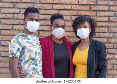 Family Looking At Camera Using Protective Mask.