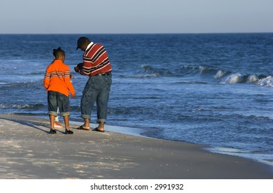 Family Looking For Clams On The Beach Of Gulf Of Mexico