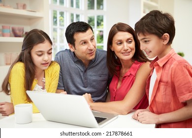 Family Looking At Laptop Over Breakfast