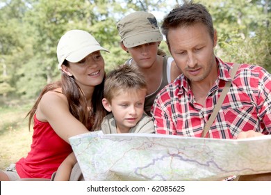 Family Looking At Map On A Hiking Day