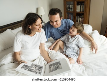 Family looking and sharing memories by the photo album - Powered by Shutterstock