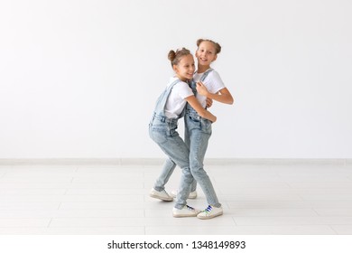 Family and love concept - two smiling twin sisters hugging over white background