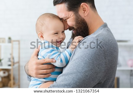 Family love and joy. Happy father embracing with his laughing adorable baby