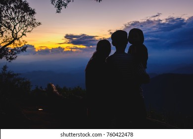 Family Lovers Father And Mother And Son In Silhouette At Sunset Background.