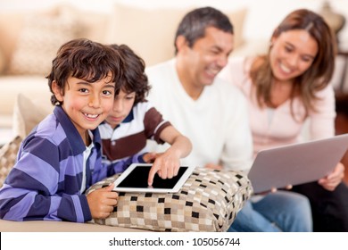 Family Loving Technology With A Laptop And Tablet Computer