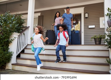 Family With Luggage Leaving House For Vacation