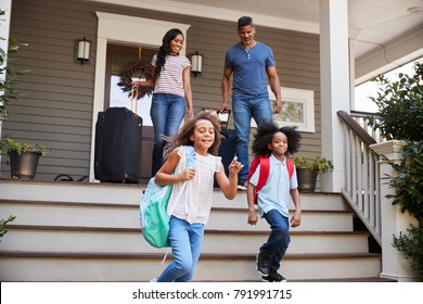 Family With Luggage Leaving House For Vacation