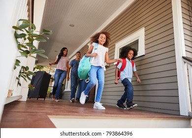 Family With Luggage Leaving House For Vacation