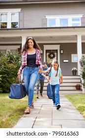 Family With Luggage Leaving House For Vacation