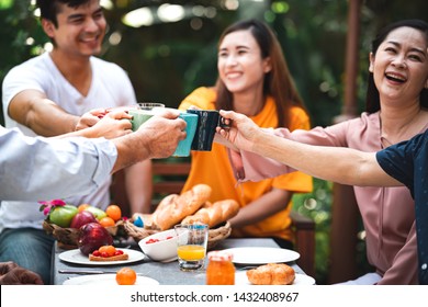 Family Lunch Outdoor. Married Mix Race Couple With Grand Parents. White Man, Asian Pregnant Woman With Senior Asian Couple In Tropical Garden. Happy Smile And Toasting.