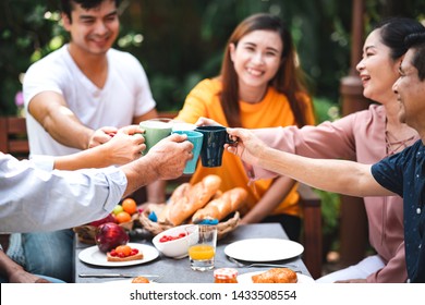 Family Lunch Outdoor. Married Mix Race Couple With Grand Parents. White Man, Asian Pregnant Woman With Senior Asian Couple In Tropical Garden. Cheering With Coffee Cup.