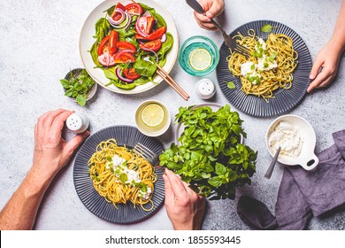 Family Lunch Table, Top View. Peoples Hands Eating Italian Pasta With Ricotta And Fresh Vegetables Salad. Italian Cuisine Concept.