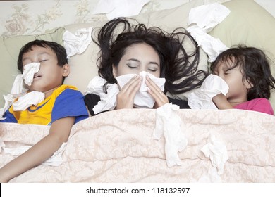 Family Is Lying On A Bed Due To Flu In Winter