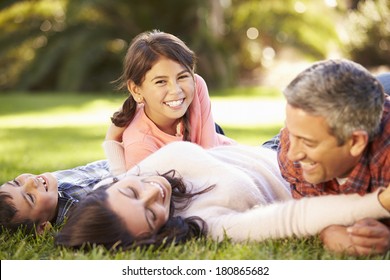 Family Lying On Grass In Countryside