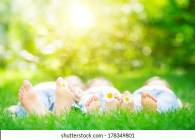 Family lying on grass outdoors in spring park