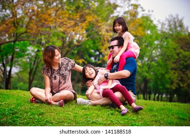 Family lying outdoors being playful and smiling, Outddor portrait