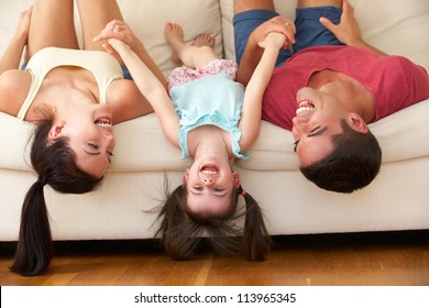 Family Lying Upside Down On Sofa With Daughter - Powered by Shutterstock