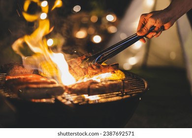 Family making barbecue meat grill in dinner party camping at night - Powered by Shutterstock