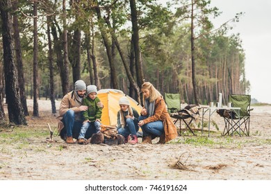 Family Making Campfire Together While Having Trip On Autumn Day