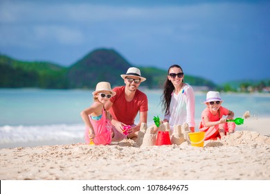 Family Making Sand Castle At Tropical Beach