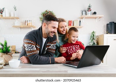 Family Man Woman And Little Son Having Fun Shopping Online Using Laptop, Choosing Gifts For Christmas And New Year