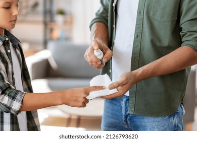 Family, Medicine And Health Concept - Close Up Of Father Healing Son's Injured Finger With Antiseptic At Home