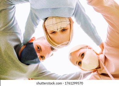 Family Members Embracing Each Other, Smiling In The Camera Wearing Cloth Face Masks. Father, Mother And Daughter Protect Themselves From The Virus. Selective Focus