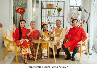 Family members wearing traditional costumers when celebrating Tet at home - Powered by Shutterstock