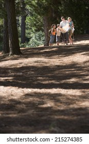 Family, In Mid-distance, Hiking Along Woodland Trail, Consulting Map, Smiling