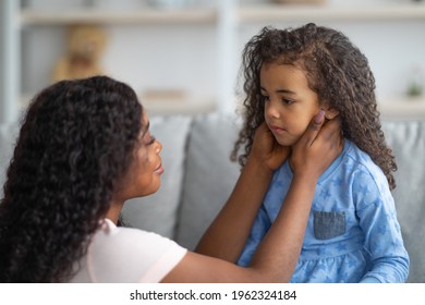Family misunderstanding, childhood problems concept. Young black mother comforting her sad offended daughter after quarrel at home. African American woman calming down her child - Shutterstock ID 1962324184