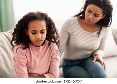 Family Misunderstanding, Childhood Problems. Sad offended black daughter sitting on the couch, turning back to mother after quarrel at home, upset woman asking resentful girl what's wrong - Powered by Shutterstock