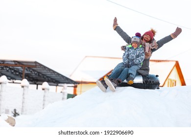 Family Mom And Child Winter Activity, Slide From Snow Hill Together On The Snow Tubing